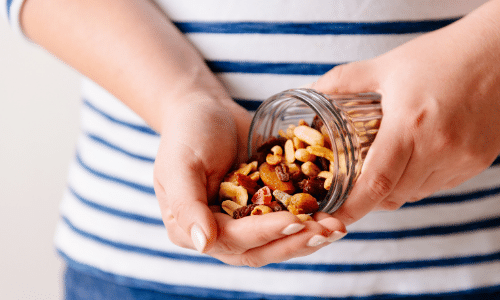 Person pouring out nuts in hand