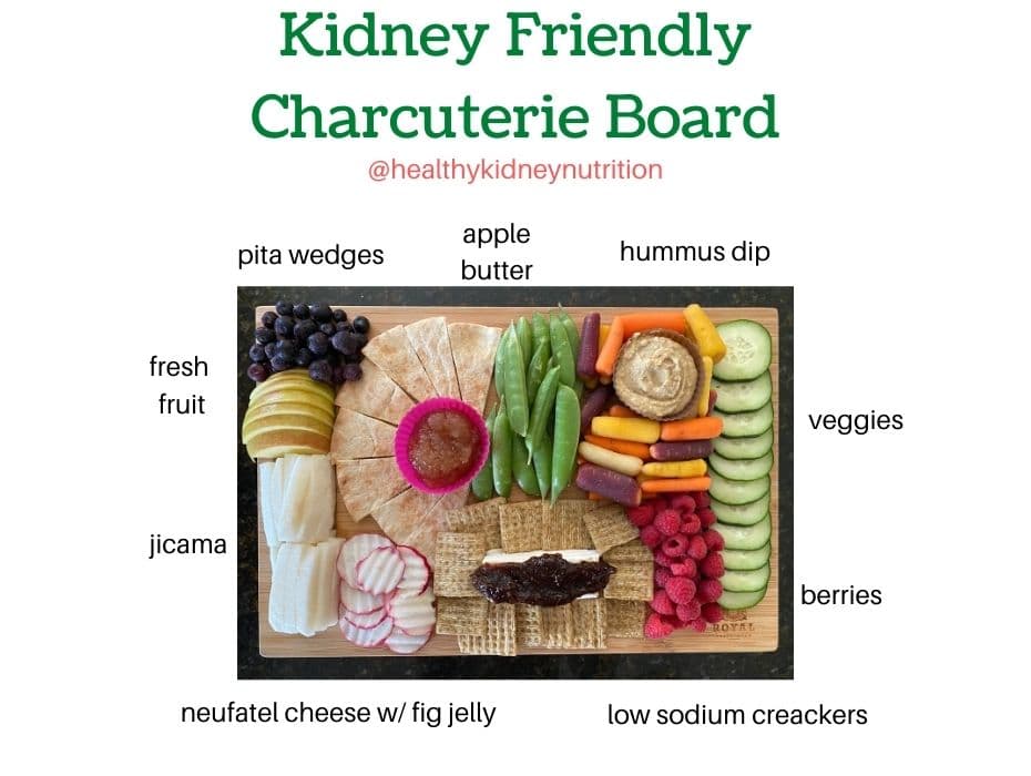 Kidney Friendly Charcuterie Board with berries, apple butter, hummus, pitas,veggies, low sodium crackers, creams cheese, fig jelly, and jicama